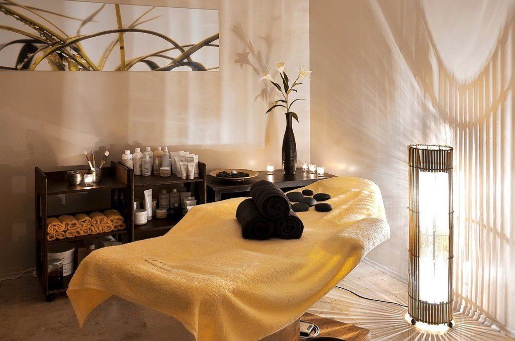 Une salle de massage tamisée, pierres chaudes et lumière douce